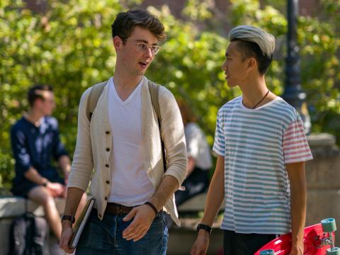 two people talking with skateboard unh campus