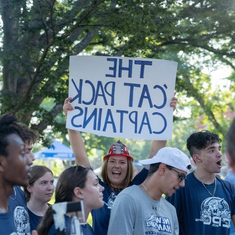 Student holding up sign that reads, "The Cat Pack Captains".